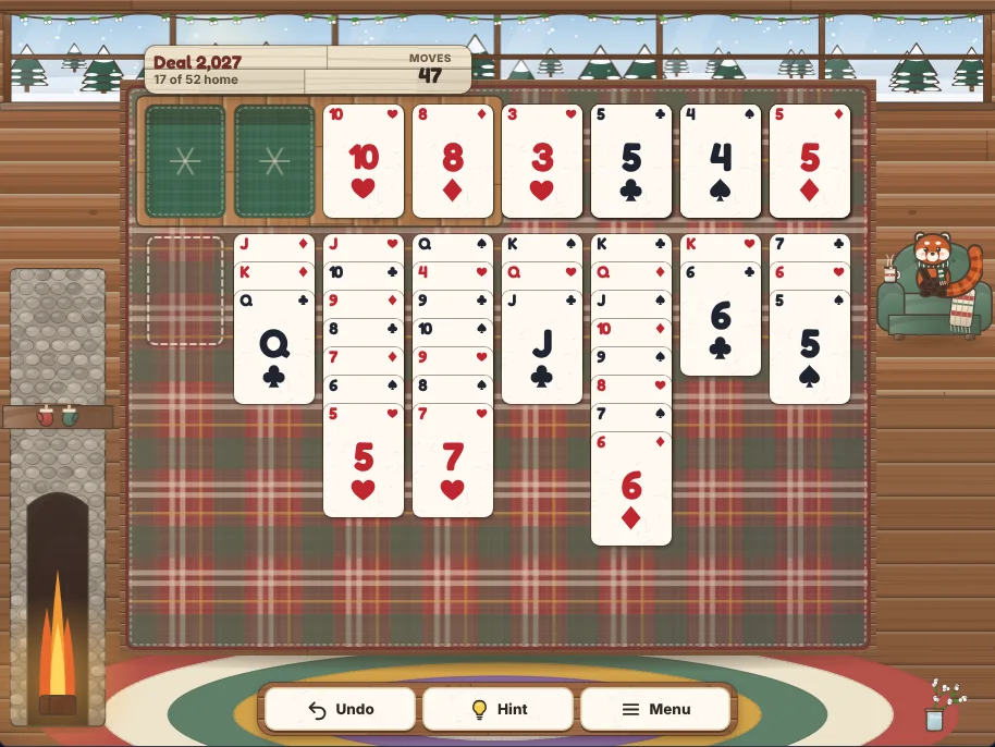 Actual Snowberry Cabin Solitaire gameplay in a desktop browser: deal 2,027 after 47 moves, with 17 cards on the foundations, the 10 of hearts and the 8 of diamonds parked in two of the four free cells, an empty first column and long runs built down in alternating colors, while Maple the red panda sits in her armchair by the window.